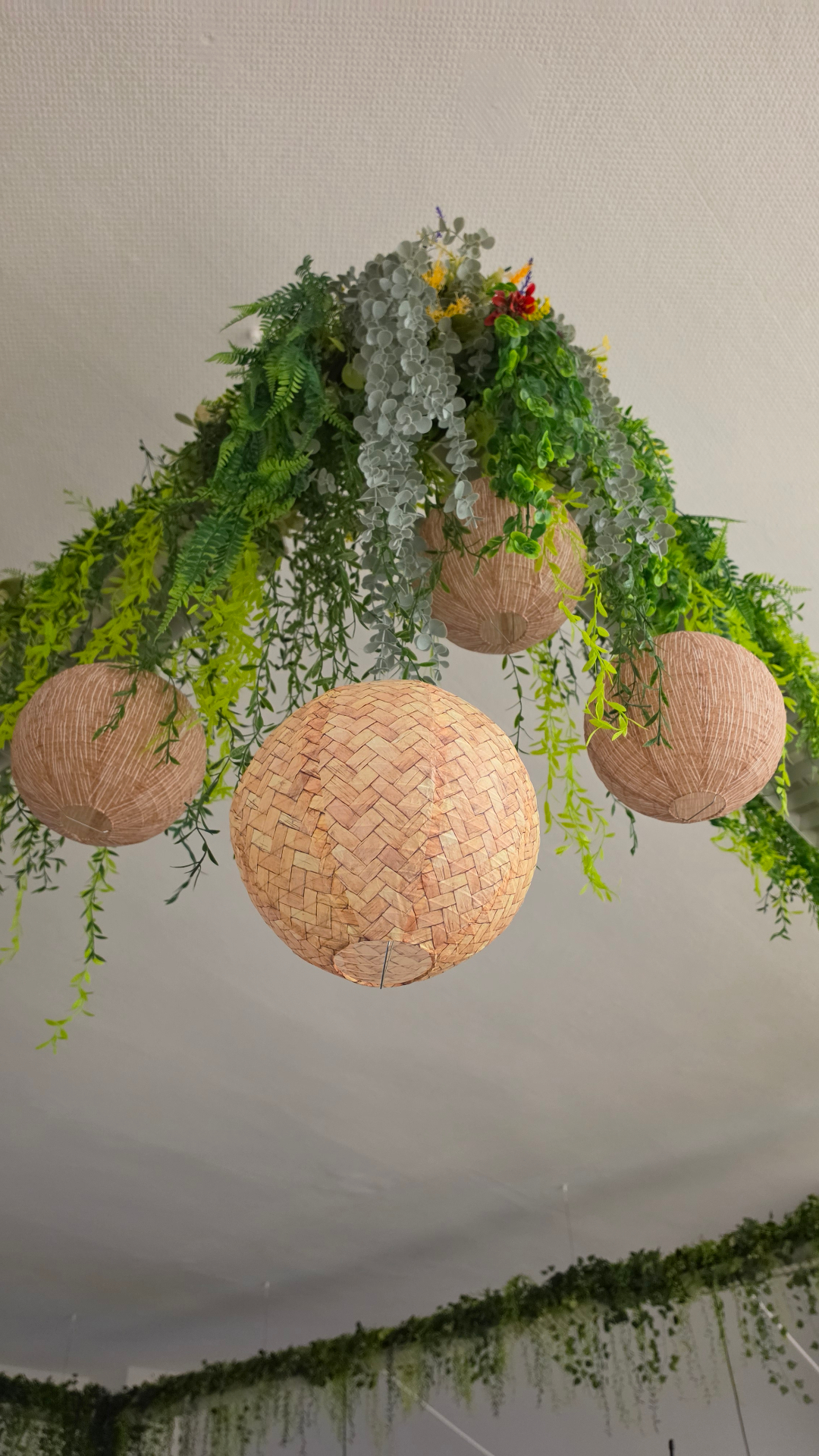 Deko aus Pflanzen und Lampions an der Decke